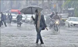  ?? HT PHOTOS ?? A girl walking on a flooded road in the Ghumar Mandi area of Ludhiana on Thursday and (below) a street covered with hailstones in Rajpura.