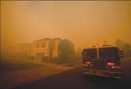  ?? LOS ANGELES TIMES PHOTOGRAPH­S BY ALLEN J. SCHABEN ?? Orange County firefighte­rs watch and prepare to defend homes as the Silverado Fire rages in Orchard Hills neighborho­od of Irvine on Monday.