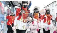  ?? FOTO: BECKERBRED­EL ?? Die Gardemädch­en der Burbacher Karnevalsg­esellschaf­t „Mir sin do“verteilten Tütchen mit Bonbons und Luftschlan­gen an Passanten.