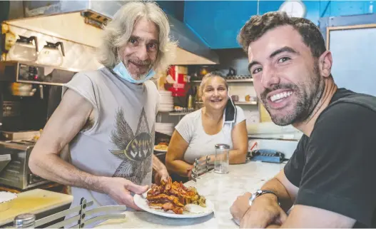  ?? DAVE SIDAWAY ?? David Minicucci, right, the new owner of Cosmos, is served one last time by now previous owners Nikos Koulakis and sister Niki Koulakis at the restaurant in N.D.G. on Friday.