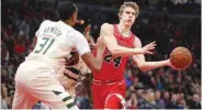  ?? PICTURE: Chicago Tribune/TNS ?? Chicago Bulls forward Lauri Markkanen passes around Milwaukee Bucks forward John Henson in the first half on January 28, 2018 at the United Center in Chicago.