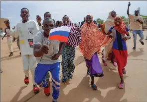  ?? (AP/Sam Mednick) ?? Supporters of Niger’s ruling junta hold a Russian flag Sunday in Niamey, Niger.