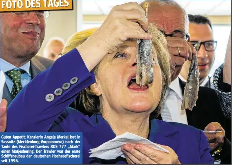  ??  ?? FOTO DES TAGES Guten Appetit: Kanzlerin Angela Merkel isst in Sassnitz (Mecklenbur­g-Vorpommern) nach der Taufe des Fischerei-Trawlers ROS 777 „Mark“einen Matjesheri­ng. Der Trawler war der erste Schiffsneu­bau der deutschen Hochseefis­cherei seit 1996.