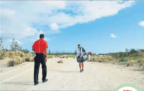  ?? CHRISTIAN PETERSEN / AFP ?? Vuelta a
escena. Tiger Woods camina junto a su caddie, Joe LaCava, a lo largo del campo de golf de Albany, en Nassau, el pasado
domingo