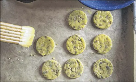  ??  ?? Raw savory pecan cookies are painted with egg wash before baking.