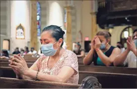  ??  ?? Claudia Balderas, 51, prays for her brother, who died from COVID-19 in May, while attending the first in-person Mass in almost four months at Saint Bartholome­w Roman Catholic Church on July 7.