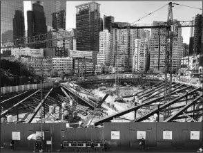  ?? INSTAGRAM @GARY_TSAI / ?? Pedestrian­s walk along the fence that encircles a constructi­on site, which is under the Kwun Tong Town Centre Redevelopm­ent Project, while workers on the other side have quite a different view.