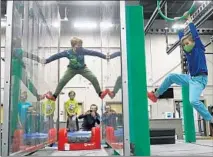  ?? JOHN J. KIM/CHICAGO TRIBUNE ?? Eight-year-old Frederick Jozwiak, left, watches his brother, Julian, 10, hang off an apparatus, as their brother, Vincent, 4, and their dad, Maciek, watch during Frederick’s birthday party at Ultimate Ninjas on Feb. 19 in Glenview. It was the first birthday party event held in the obstacles and fitness facility this year since COVID-19 restrictio­ns were loosened.