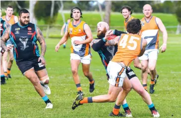  ??  ?? Above: Korumburra-Bena player Ricky Muir applies a tackle to Travis Ramsdale as his Cora Lynn teammate Shean Taylor moves to assist.
Right: Korumburra-Bena’s Zac Van Delft spoils the marking attempt of Joshua Wilson for Cora Lynn.