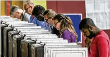  ?? JOHN SPINK / JSPINK@AJC. COM ?? Voters ponder the ballots with multiple races at stake at Henry W. Grady High School in Atlanta on Tuesday.