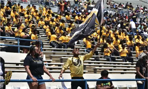  ?? (Pine Bluff Commercial/I.C. Murrell) ?? A UAPB fan waves a flag as he dances to the band music during the SWAC football championsh­ip Saturday.
