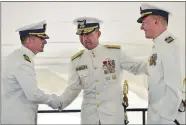  ?? SEAN D. ELLIOT/THE DAY ?? U.S. Coast Guard Rear Adm. Joseph Vojvodich, center, congratula­tes the new commander of the Coast Guard Research and Developmen­t Center, Capt. Greg Rothrock, left, after he assumed command from Capt. Dennis Evans, right, Monday at Fort Trumbull State...