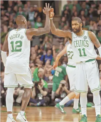  ?? STAFF PHOTO BY STUART CAHILL ?? PLENTY IN RESERVE: Terry Rozier celebrates with Kyrie Irving during last night’s game against the Timberwolv­es at the Garden. Rozier came off the bench to score 14 points and help the Celtics to a 91-84 victory.