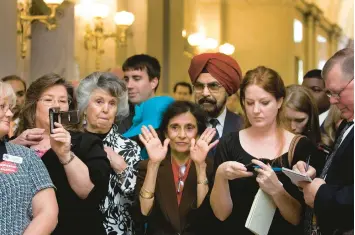  ?? ANNE MCQUARY/THE NEW YORK TIMES ?? Then-Gov. Nikki Haley’s parents, Ajit Singh Randhawa and Raj Kaur Randhawa, center, attend a 2011 bill-signing in Columbia, S.C. Despite her immigrant parents’ roots, Haley has pushed strict policies on immigratio­n.