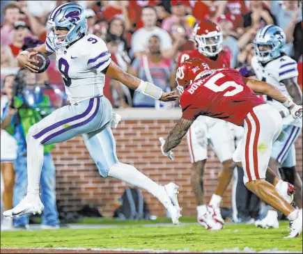  ?? Nate Billings The Associated Press ?? Kansas State quarterbac­k Adrian Martinez leaves Oklahoma safety Billy Bowman in his wake on one of his four scoring runs Saturday in the Wildcats’ 41-34 win Saturday night at Owen Field. Martinez ran for 148 yards and threw for 234 yards and a TD.