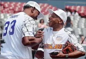  ?? DANA JENSEN/THE DAY ?? Retired NBA player Otis Thorpe, left, and music artist Jeffrey Osborne greet each other Sunday as they arrive on the field to play in Osborne’s Jeffrey Osborne Celebrity Softball Classic at Dodd Stadium in Norwich. Go to theday.com for a photo gallery.