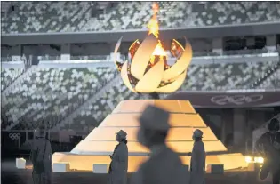  ?? DAVID GOLDMAN —THE ASSOCIATED PRESS ?? Volunteers stand as Internatio­nal Olympic Committee President Thomas Bach gives a speech during the closing ceremony of the Summer Olympics on Sunday in Tokyo.