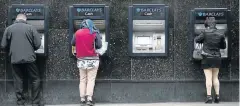  ?? Picture: BLOOMBERG ?? READY CASH: Customers use ATMs outside a Barclays Bank branch in London