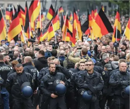  ?? © Ralf Hirschberg­er/dpa ?? 2018: Politiemen­sen stellen zich op tijdens een extreemrec­htse betoging in Chemnitz.