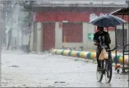  ?? DELMER MARTINEZ — THE ASSOCIATED PRESS ?? A man rides his bicycle under the rain brought by Hurricane Iota Nov. 17 in La Lima, Honduras.