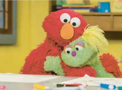  ?? .ZACH HYMAN/SESAME WORKSHOP ?? Elmo hugs his friend Karli. The Sesame Street favorite went viral on X when he asked “how is everybody doing?”