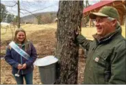  ??  ?? Toad Hill Maple Farm owner Randy Galusha, right, smiles as Upper Hudson Maple Queen Olivia Roberts, of Granville, takes part in a ceremonial tree-tapping event.