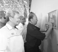  ??  ?? Pairin signing the plaque to mark the launch of the Regional Sewage Treatment Plant in Kampung Busul, Lahad Datu yesterday.