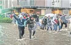  ??  ?? Sobre la calle Mariano Escobedo, decenas de personas tuvieron que caminar entre el agua, debido al lento servicio de transporte.