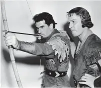  ??  ?? On target: Robin Hood star Errol Flynn watches as his archery double Howard Hill takes aim