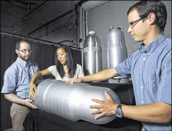  ?? DINO VOURNAS / SANDIA NATIONAL LABORATORI­ES ?? Lee Druxman, Bryn Miyahara and Andrew Van Blarigan, weapons experts, examine warhead models for the advance cruise missile. The U.S., Russia and China are pursuing a new generation of nuclear weapons.