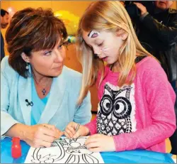  ?? STEVE MacNAULL/The Okanagan Saturday ?? Premier Christy Clark colours with Sonia Wannop, 7, at a Good Friday event at Westbank Lions Community Centre.