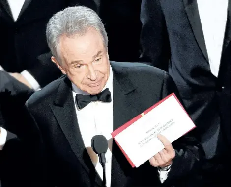  ?? CHRIS PIZZELLO/THE ASSOCIATED PRESS ?? Presenter Warren Beatty holds up an envelope revealing Moonlight as the winner of best picture at the Oscars on Sunday, at the Dolby Theatre in Los Angeles.