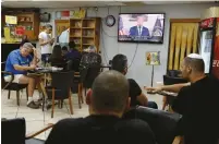  ?? (Amir Cohen/Reuters) ?? PEOPLE IN an Ashkelon coffee shop watch US President Donald Trump speak at the White House yesterday.