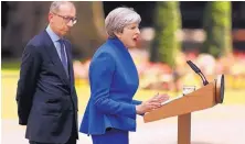  ?? TIM IRELAND/ASSOCIATED PRESS ?? British Prime Minister Theresa May speaks to reporters Friday after consulting with Queen Elizabeth II about forming a coalition government. At left is her husband, Philip.