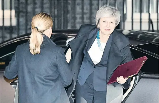  ?? BEN STANSALL / AFP ?? La primera ministra británica, Theresa May (en la imagen, a su regreso anoche al 10 de Downing Street), aguantó en el Parlamento un chaparrón pero no perdió la sonrisa