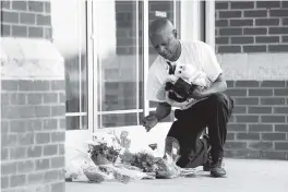  ?? SEAN RAYFORD Getty Images ?? Jack Logan, founder of Put Down the Guns Young People, places stuffed animals and flowers Thursday outside of Riverview Family Medicine and Urgent Care in Rock Hill, S.C.