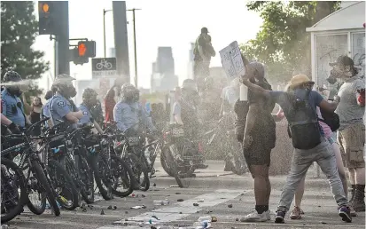  ??  ?? Police fire pepper spray at protesters outside the Third Police Precinct in Minneapoli­s on Wednesday. The station has become the site of an ongoing protest after the police killing of George Floyd. Four Minneapoli­s police officers have been fired over the death. — AFP