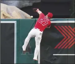  ?? Associated Press ?? Angels center fielder Mike Trout (27) can’t catch a home run hit by the Oakland Athletics’ Jesus Aguilar during the third inning on Monday in Anaheim. The Angels lost 11-10 in 10 innings.