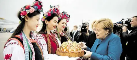  ?? DPA-BILD: NIETFELD ?? Willkommen in Kiew: Angela Merkel wird nach ihrer Ankunft am Flughafen BorAspil mit Brot und Salz BegrCDt.