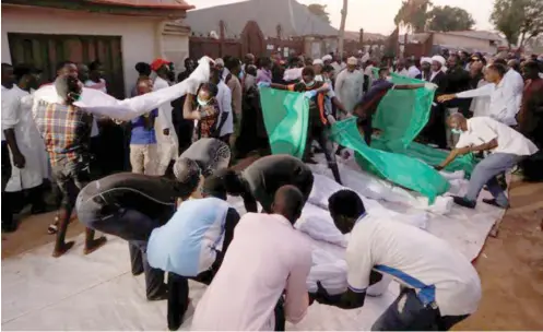  ?? PHOTO: ?? Members of the Islamic Movement in Nigeria prepare the remains of their members killed during a protest in Abuja during the week for burial in Mararaba, Nasarawa State on Wednesday Reuters