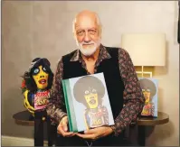  ?? Associated Press photo ?? Mick Fleetwood, the drummer and co-founder of the band Fleetwood Mac poses for photograph­s with a copy of his book "Love That Burns - A Chronicle of Fleetwood Mac, Volume One: 1967-1974" after an interview at a hotel in London, Sept. 28.