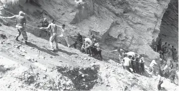  ?? — AFP photo ?? Police personnel and locals carry the injured and dead from the site of the bus accident in Ramban district.