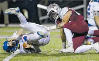  ?? STAFF PHOTOS BY C.B. SCHMELTER ?? Red Bank’s Madox Wilkey, left, is sacked by Alcoa’s Tristan Woody during a Class 3A semifinal game Friday at Alcoa High School.