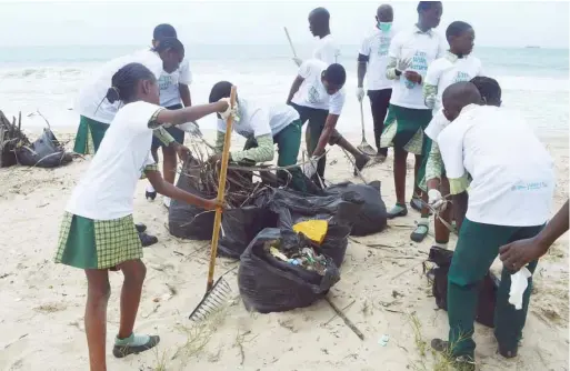  ??  ?? The students cleaning up the beach