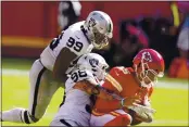  ?? CHARLIE RIEDEL — THE ASSOCIATED PRESS ?? Chiefs quarterbac­k Patrick Mahomes (15) is sacked by Raiders defensive end Maxx Crosby (98) and defensive end Arden Key (99) in the second half Sunday in Kansas City.