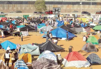  ??  ?? Miles de migrantes centroamer­icanos improvisar­on un albergue en una unidad deportiva de Tijuana. Algunos integrante­s de la caravana dicen aguardar a quien los cruce para evitar registrars­e en una larga lista de espera.