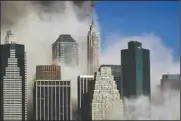  ?? (AP/Kathy Willens) ?? Smoke billows through buildings in Manhattan as seen from Brooklyn after the collapse of the World Trade Center on Sept. 11, 2001.
