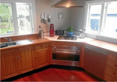  ??  ?? A tired looking kitchen with dark wooden cupboard doors and benchtops (above) can look fresh and modern (below) with fresh white doors and benchtops .