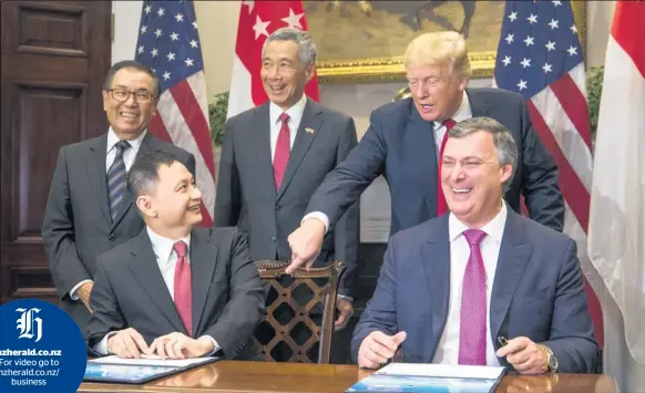  ?? Picture/ Bloomberg ?? Boeing’s Kevin McAllister (front right) and Singapore Airlines’ chief Goh Choon Phong (front left) sign the deal.