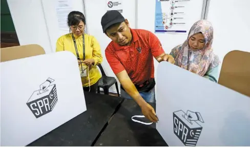  ?? ?? Prep work: Polling station personnel preparing for the upcoming elections at the Tabuan Jaya police housing multi-purpose hall polling station in Kuching, sarawak. — Zulazhar sheblee/the star